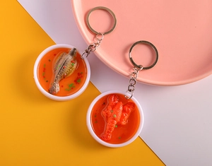 Detailed view of realistic PVC lobster and fish food models on metal keyrings