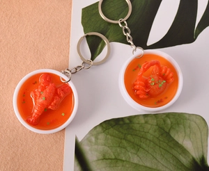 Detailed overhead view of miniature PVC resin lobster and crab food models with silver keychains