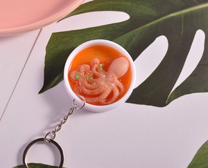 Detailed macro of a realistic PVC octopus food model keychain in a miniature bowl