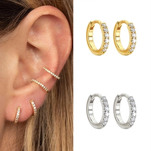 Detail showing micro-pave round hugging hoop earrings worn by a model in gold and silver