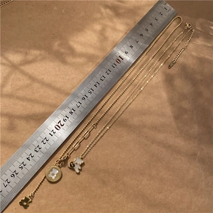 Detail view of gold-tone bear necklaces with S925 hallmark and scale measurement