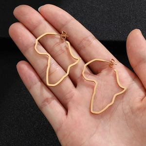 Detailed close-up of gold Africa map earrings held in hand to show size and texture