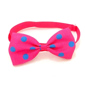 Close-up of pink pet bowtie with blue polka dots on textured grosgrain fabric