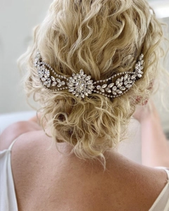 Detailed view of silver bridal hair comb with rhinestones in floral leaf design on blonde hair