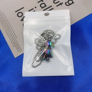 Ciondolo astronauta con finitura metallica iridescente in busta di plastica sigillata