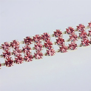 Close-up of pink three-row rhinestone pet collar with silver metal claw settings