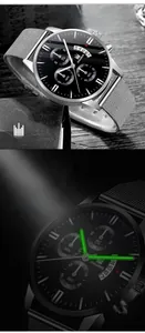 Detail of quartz watch dial with calendar window and luminous hands in dark conditions