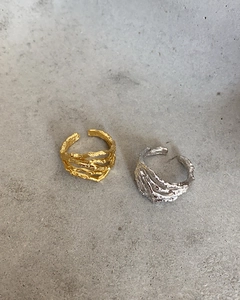 Detailed view of 925 sterling silver irregular open rings with rock texture in gold and silver
