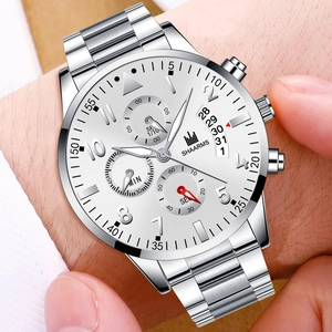 Detail of silver stainless steel watch with calendar display and chrono sub-dials on wrist