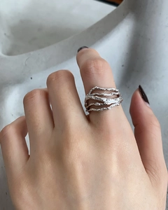Detail of 925 sterling silver liquid metal ring with irregular texture on hand