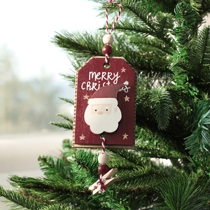 Wooden Merry Christmas photo clip ornament with Santa Claus hanging on a green Xmas tree