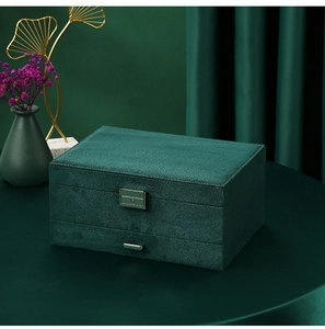 Detailed view of dark green velvet jewelry box with metallic lock and drawer handle