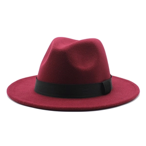 Detail of burgundy wool fedora hat featuring a classic black grosgrain ribbon and side knot