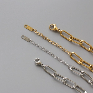 Close-up of gold and silver paperclip link chains with K18 stamp and lobster clasp