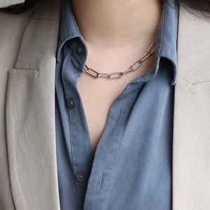Detailed view of silver paperclip link chain necklace on model for professional look