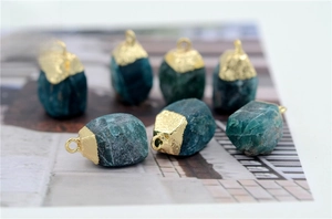 Close-up of seven raw turquoise natural stone pendants with gold-plated metal edges