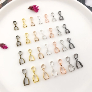 Macro shot of assorted metal pendant pinch bails in various colors and sizes for jewelry DIY