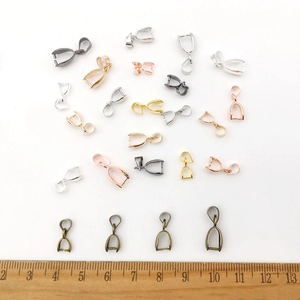 Detailed view of multi-color pendant clasp variety with wood ruler for scale