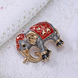 Detailed shot of ethnic elephant brooch with red enamel and gold auspicious clouds