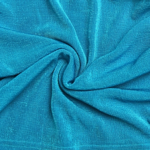 Detailed macro view of the teal knitted fabric texture with natural soft folds