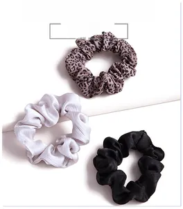 Three-piece scrunchie set featuring leopard print and satin fabric in brown and grey