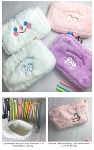 Detail of plush cosmetic bag with embroidered cartoon animals and pearl zipper puller