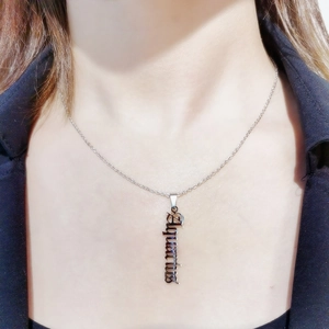Silver Aquarius zodiac necklace featuring gothic vertical letter pendant on a female model