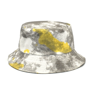 Detailed view of the gray and yellow graffiti tie-dye fabric on a reversible bucket hat