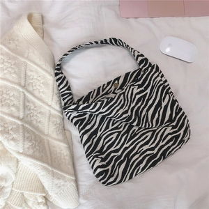 Detail of zebra print canvas bag with magnetic metal closure and inner pocket storage