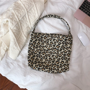 Detailed flat lay of leopard print canvas tote bag with shoulder strap and large capacity