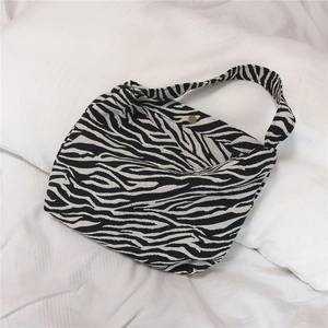 Detail of hobo bag with zebra print texture, sturdy canvas and brass metal fastener