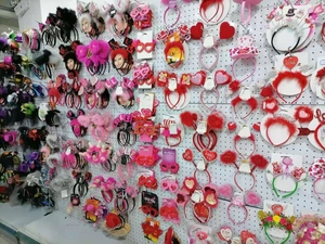 Selection of festive party headbands and decorative glasses on a wholesale display wall