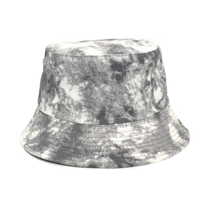 Dettaglio ravvicinato della trama tie-dye grigio e bianco sul cappello a secchiello in cotone
