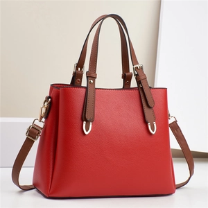 Red lychee pattern leather Boston handbag with brown handles and gold hardware accents