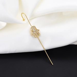Hamsa hand gold crawler earring with sparkling cubic zirconia on a silk background