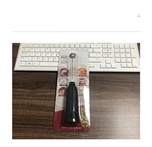 Detail view of electric handheld milk frother in blister packaging with stainless steel whisk