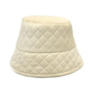 Detail of cream quilted bucket hat showing soft velvet texture and rhombic stitching