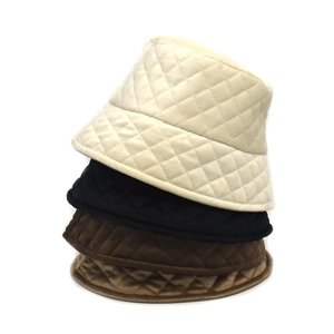 Close-up of diamond quilted bucket hats in cream, black, brown, and khaki fleece