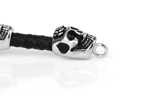Macro shot of punk woven black leather bracelet with vintage silver skull clasp detail