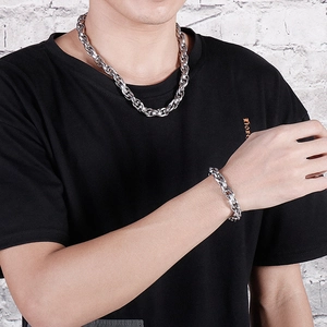 Detail shot of men's chunky silver steel curb chain necklace and bracelet on model