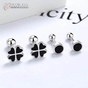 Macro shot of 925 silver clover and round earrings with black enamel and screw-back