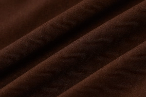 Gros plan sur le tissu en maille côtelée marron foncé avec drapé doux et texture chic