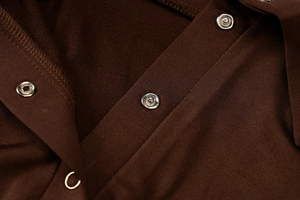 Vue macro détaillée de la texture en sergé marron foncé et des boutons-pression en métal