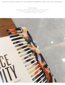 Macro detail of wide-tooth hair comb with artistic multicolored leopard acetate texture