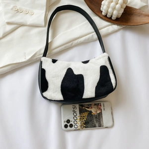 Chic zebra pattern plush underarm bag with black leather strap on a decorative background