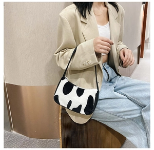 Model showcasing a zebra print faux fur shoulder bag with a stylish beige blazer outfit