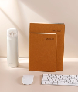Detailed macro view of brown faux leather A5 business notebook set on office desk