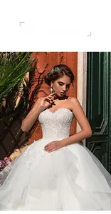 Detailed view of the off-shoulder white lace bodice and voluminous tulle skirt of the wedding gown