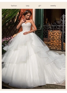 Detail of white wedding dress featuring lace embroidery bodice and layered tulle skirt