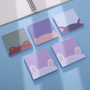 Flat lay of five animal-themed sticky note pads in various pastel colors on a blue desk